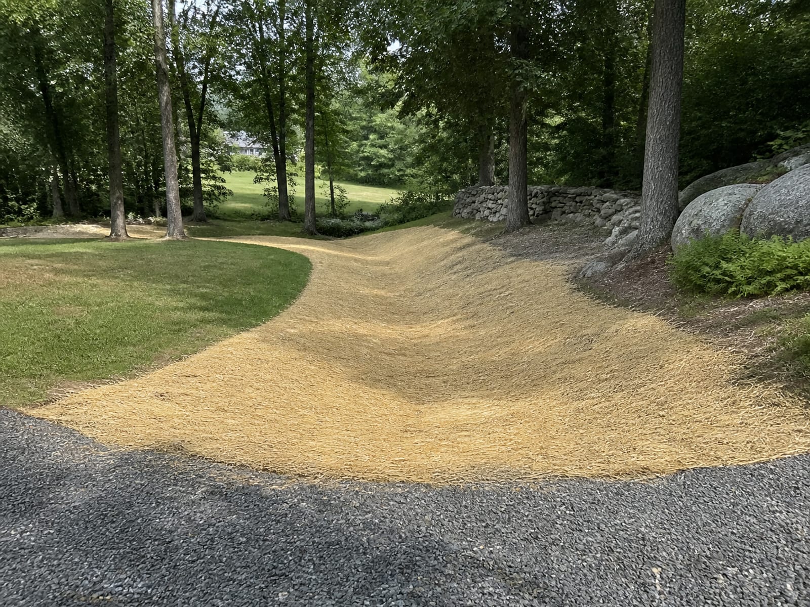 Backfilled and rough graded work area on a rural property with restored surface drainage and straw over freshly seeded soil
