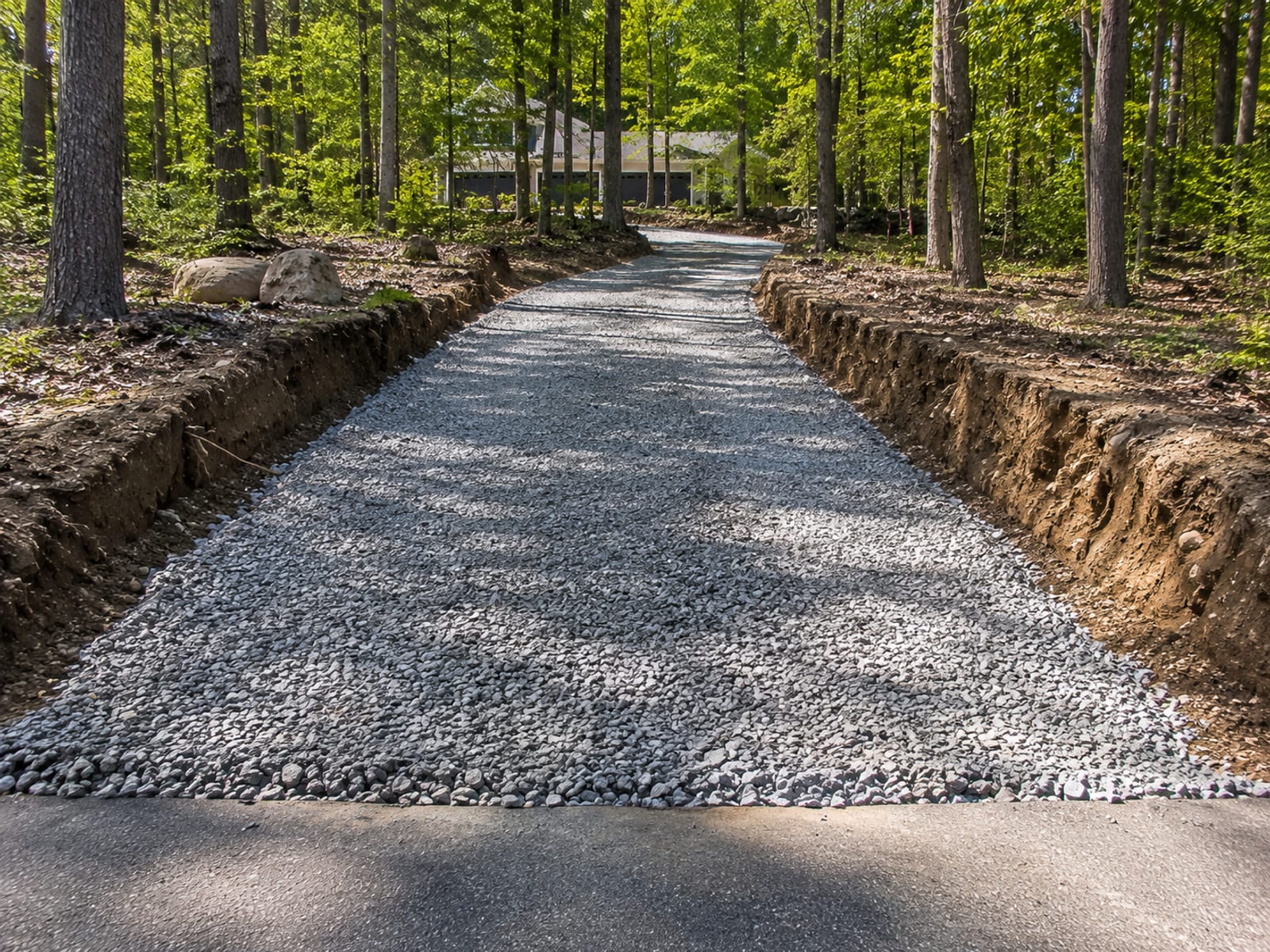 Freshly excavated and graded driveway subbase preparation on a Connecticut residential property