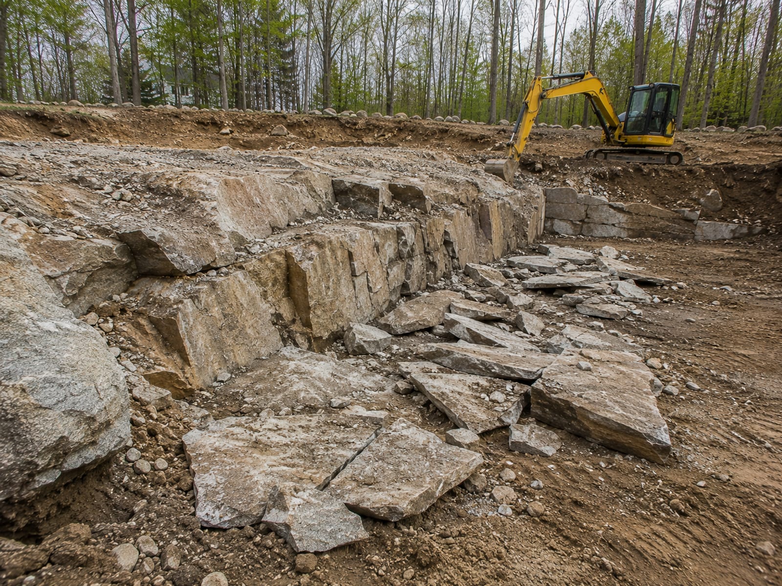 Exposed granite ledge rock being excavated from a Connecticut residential building site