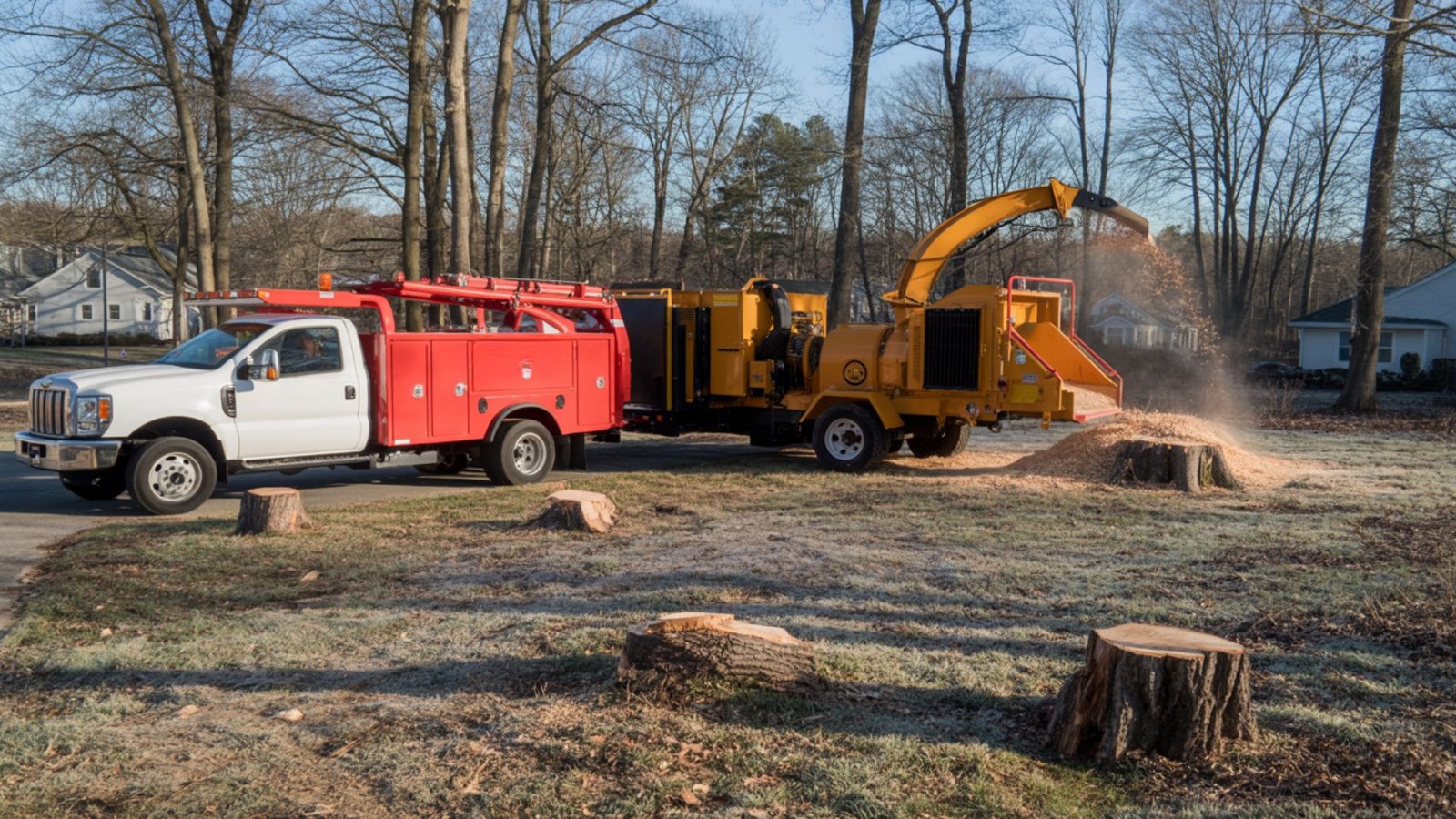 Tree removal truck and wood chipper on cleared residential lot in Connecticut